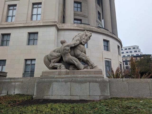 Man Controlling Trade statue outside the Federal Trade Commission.