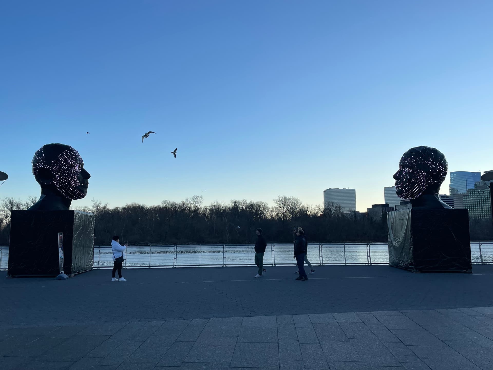 Glowing heads somewhere by the water.