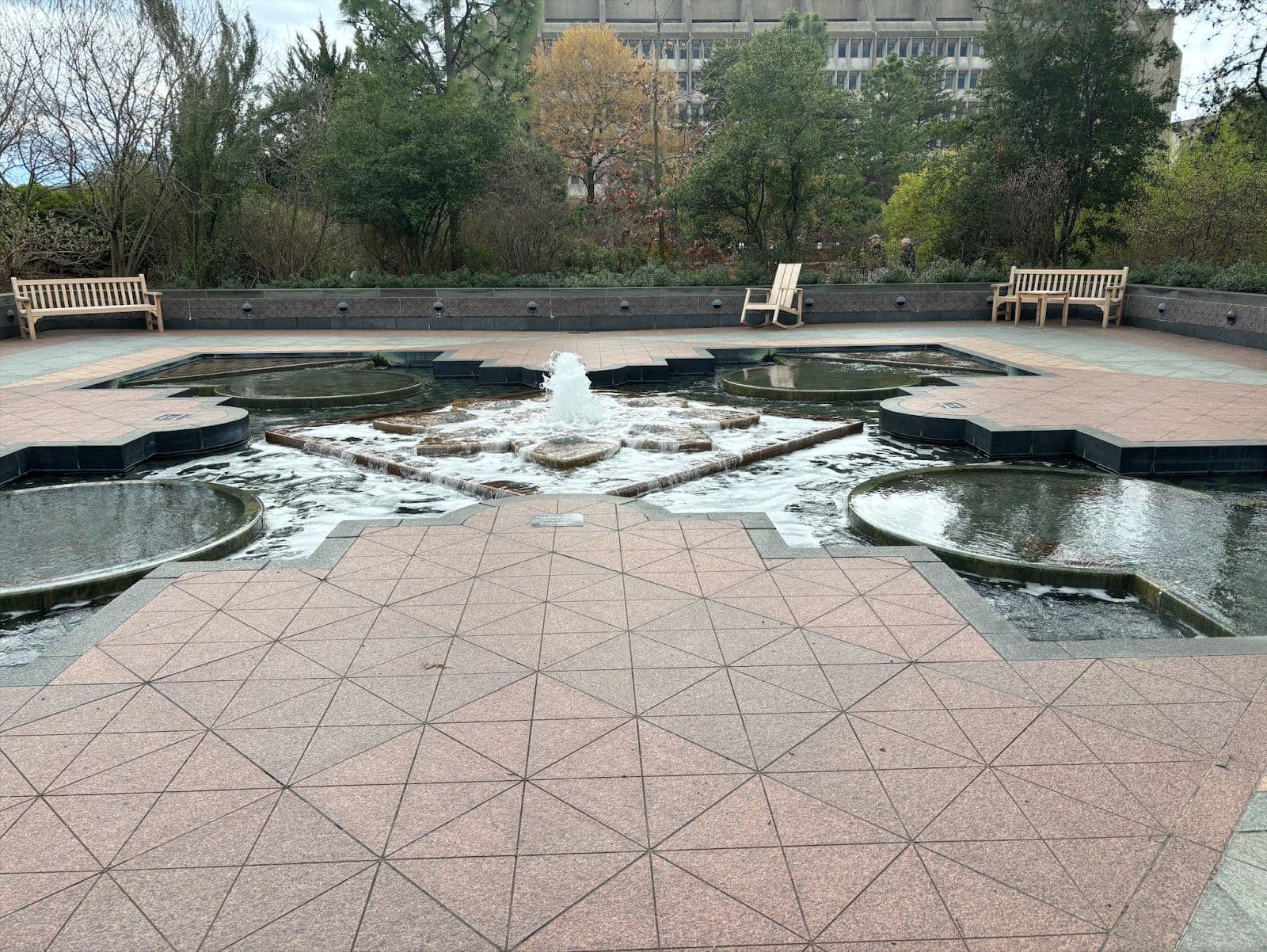 Benches surround a peaceful water fountain.
