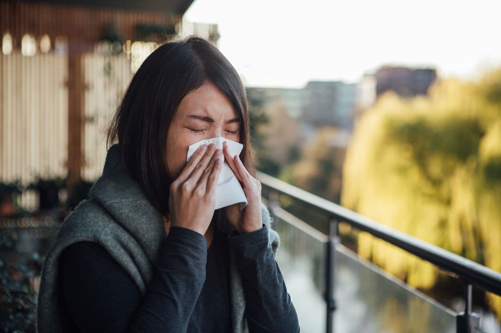 Woman sneezes into tissue during allergey season.